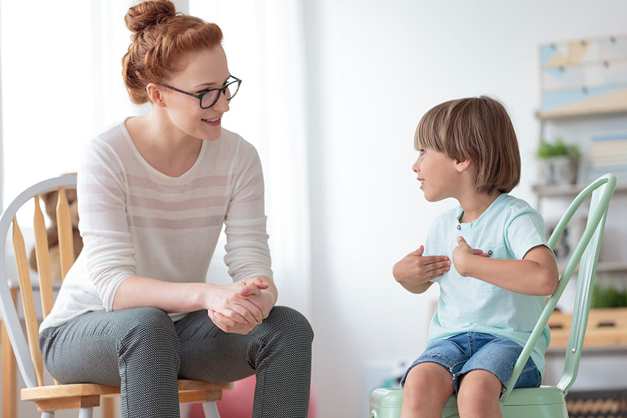 A CASA advocate smiling and talking to a young child in the foster care system in Springfield, IL. A CASA volunteer speaking to a child.