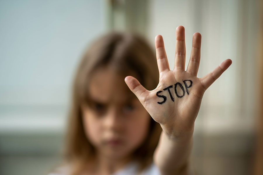 A child holding out their hand with the word stop written over it to symbolize the end of child abuse in Springfield, IL.