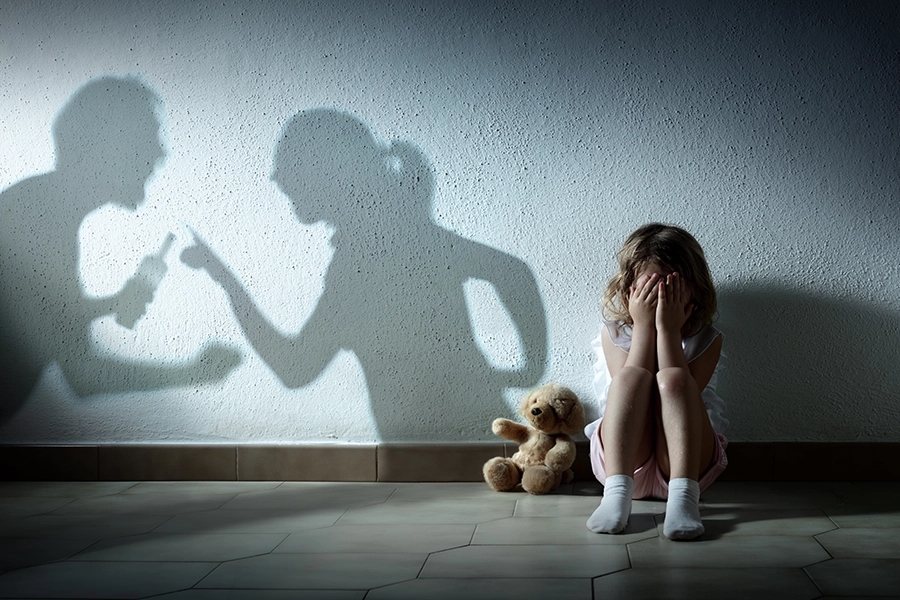 A little girl from Sangamon County, IL is hiding in the corner from her arguing parents as shadows hint at possible domestic violence.